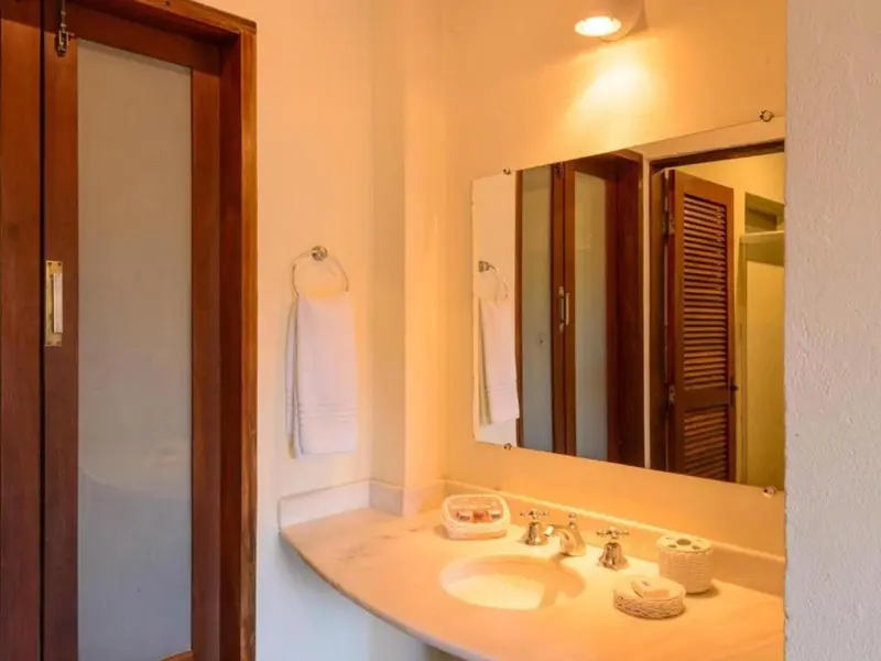 Une salle de bain lumineuse avec un lavabo et un miroir.