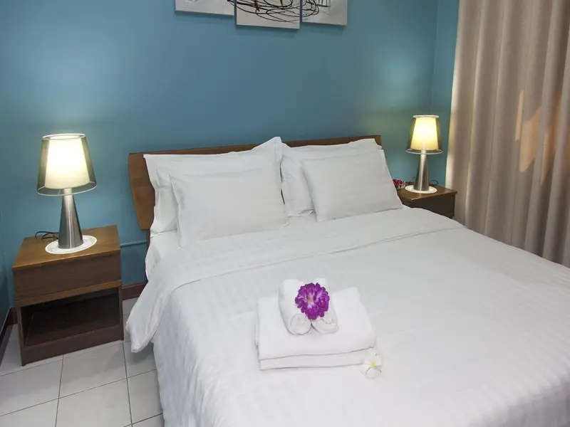 Une chambre lumineuse avec un grand lit recouvert de draps blancs.
