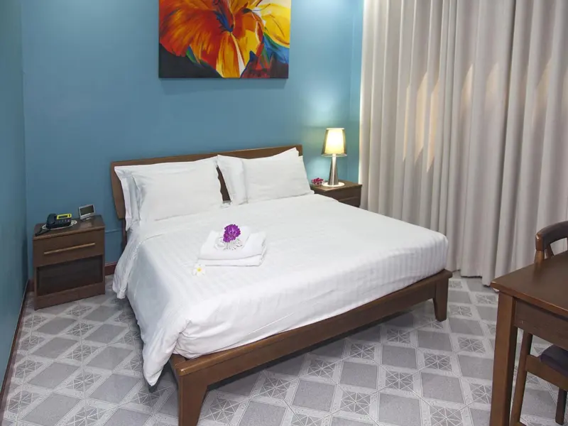 Une chambre lumineuse avec un grand lit recouvert de draps blancs.