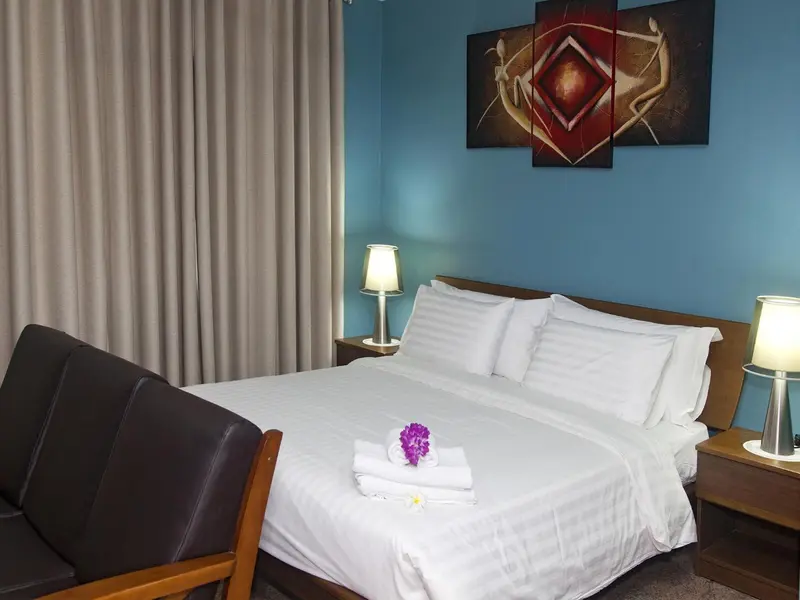 Une chambre avec un lit double et un coin salon.