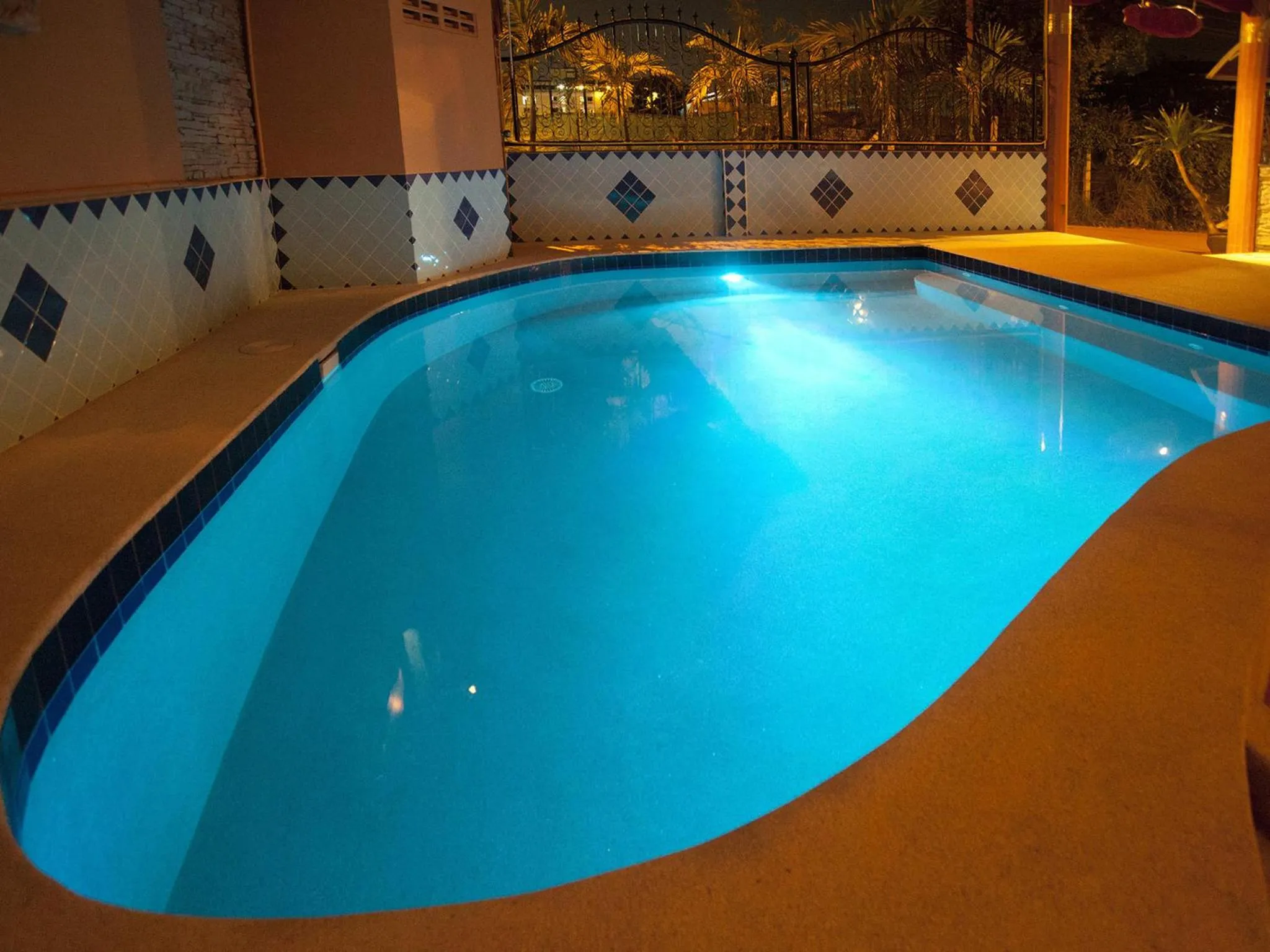 Piscine illuminée avec un éclairage bleu la nuit.