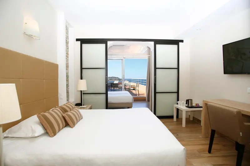 Une chambre lumineuse avec un grand lit et une vue sur la mer.