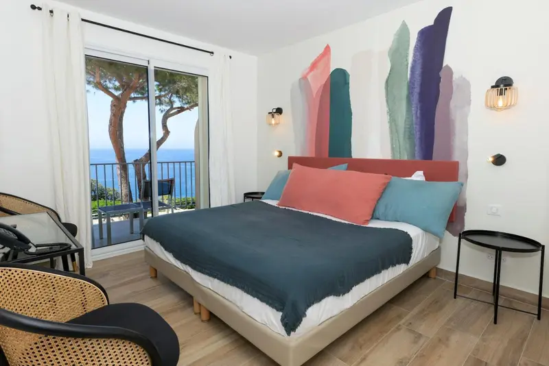 Une chambre lumineuse avec un grand lit donnant sur la mer.