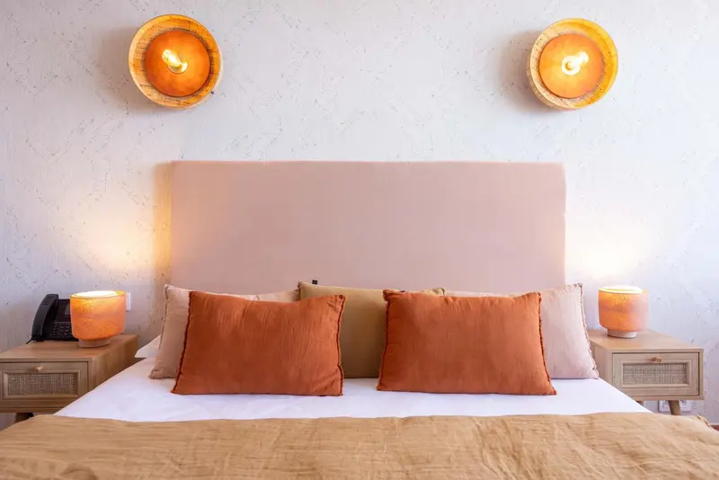 Un lit double avec des oreillers et des coussins dans une chambre.
