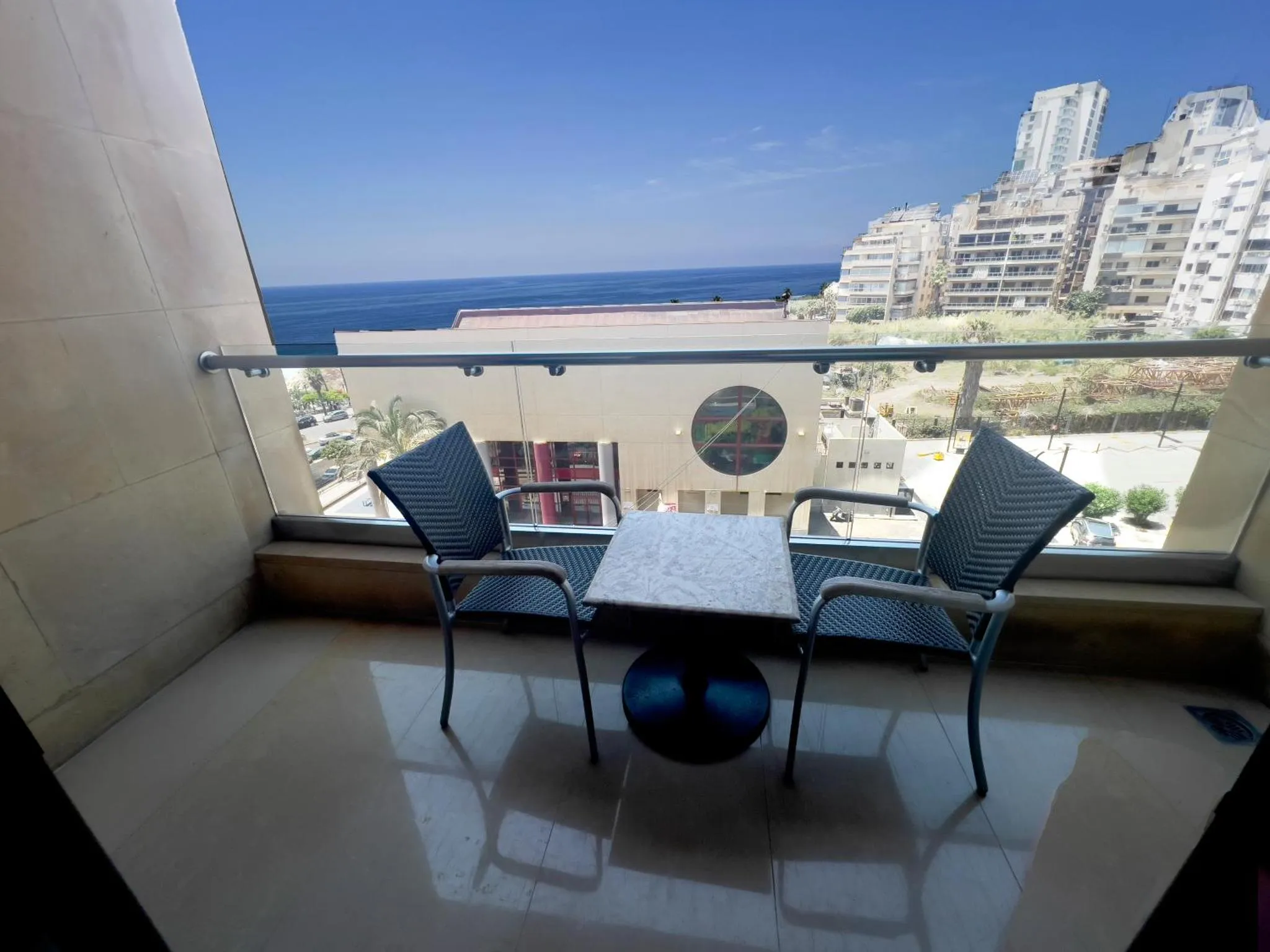 Terrasse avec mobilier d'extérieur et vue sur la mer.