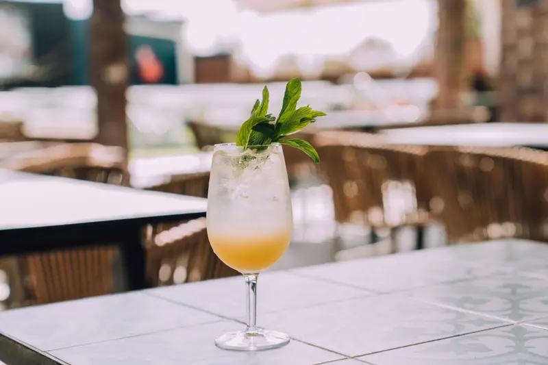 Un cocktail rafraîchissant dans un verre sur une table en extérieur.