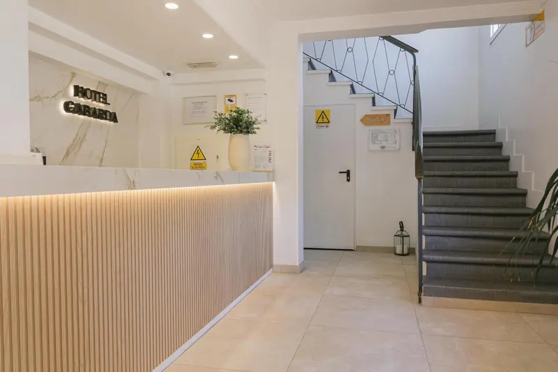 Un comptoir d'accueil moderne dans un hall d'hôtel avec un escalier.