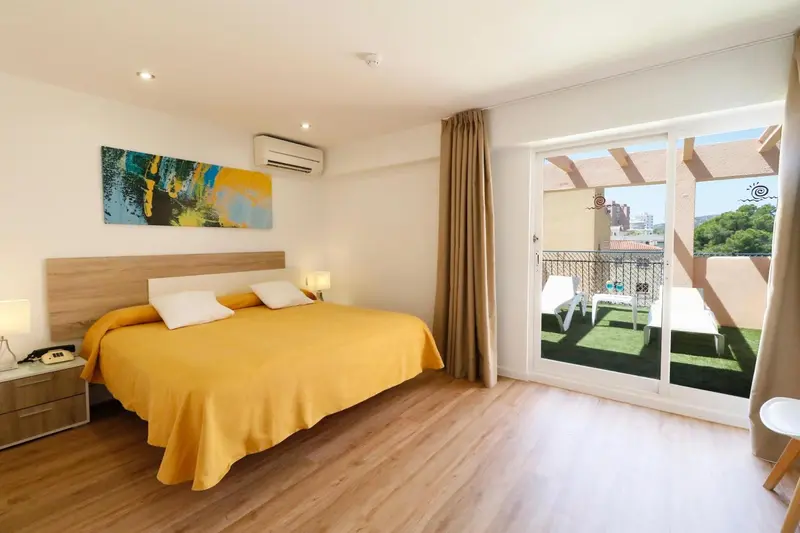 Une chambre lumineuse avec un grand lit et un accès à une terrasse.