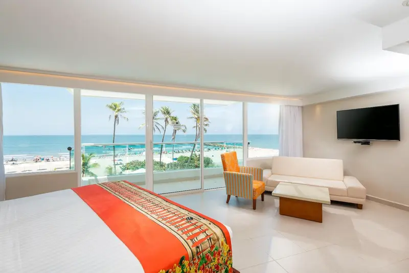 Chambre lumineuse avec vue sur la mer et un espace salon.