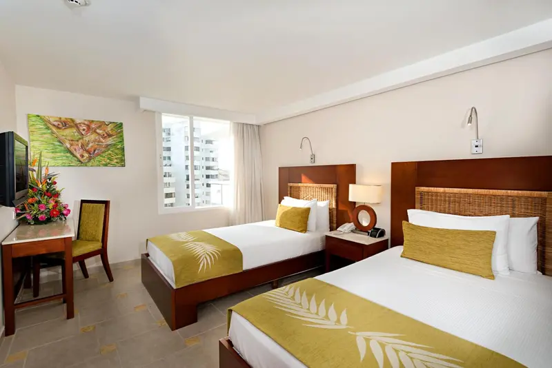 Une chambre lumineuse avec deux lits simples et une décoration tropicale.