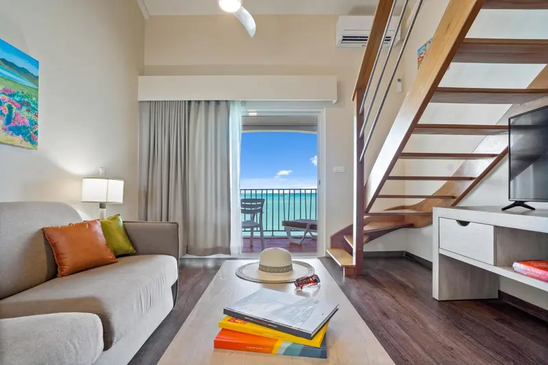 Un salon lumineux s'ouvre sur une terrasse avec vue sur la mer.