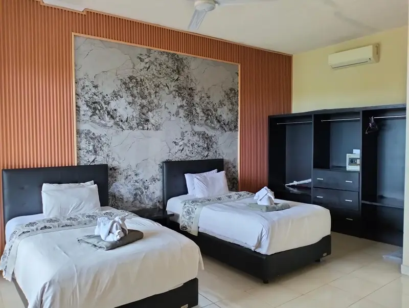 Une chambre lumineuse avec deux lits simples et un mur décoratif.