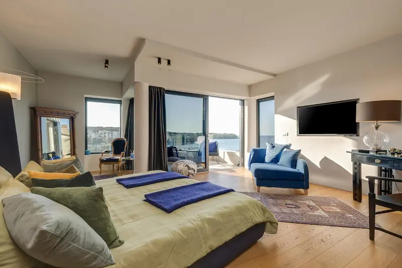 Une chambre spacieuse avec un grand lit et un accès à une terrasse.