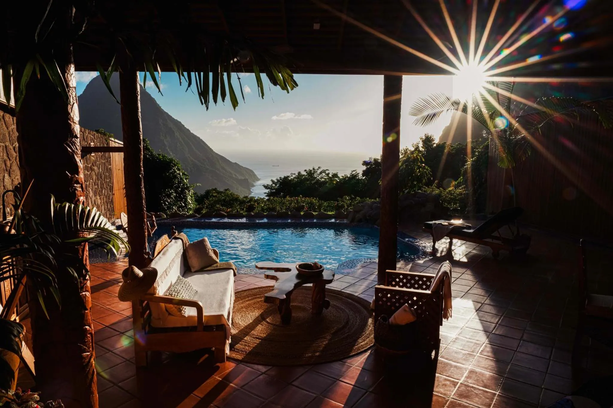 Un espace de détente extérieur avec piscine et mobilier de jardin offre une vue sur la mer et les montagnes.