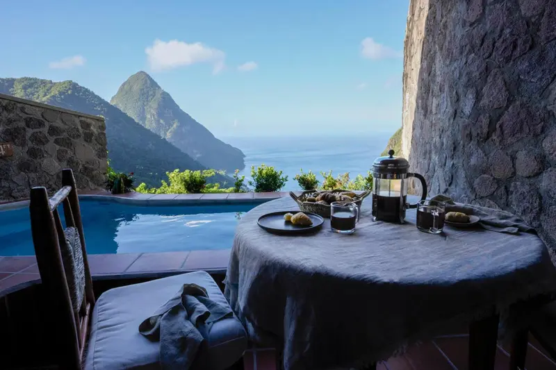 Une table est dressée devant une piscine avec vue sur un paysage montagneux.