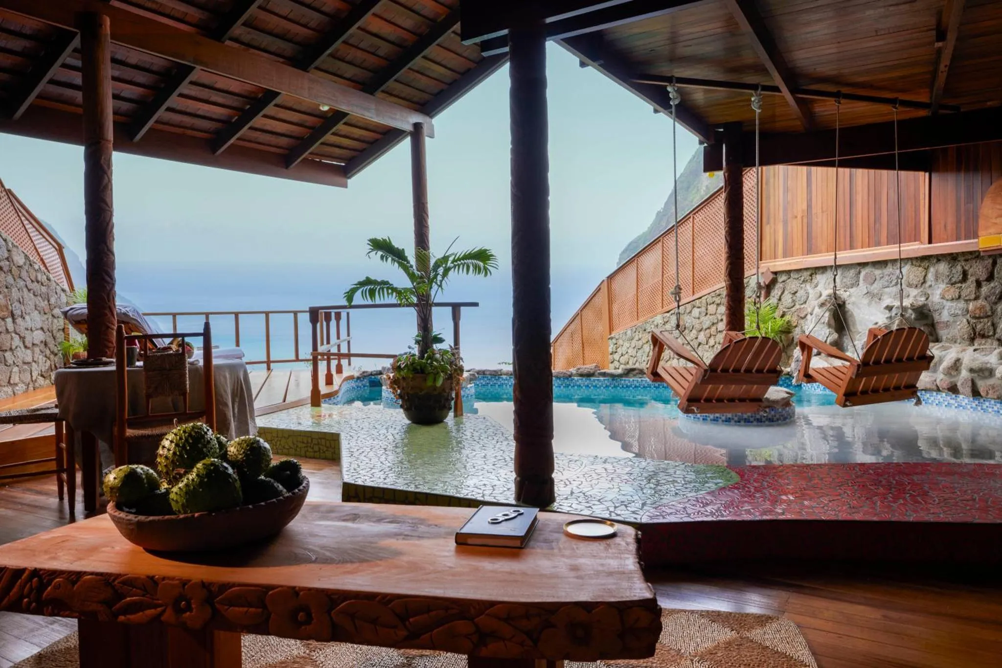 Vue sur la mer depuis une terrasse avec un espace de détente et une petite piscine.