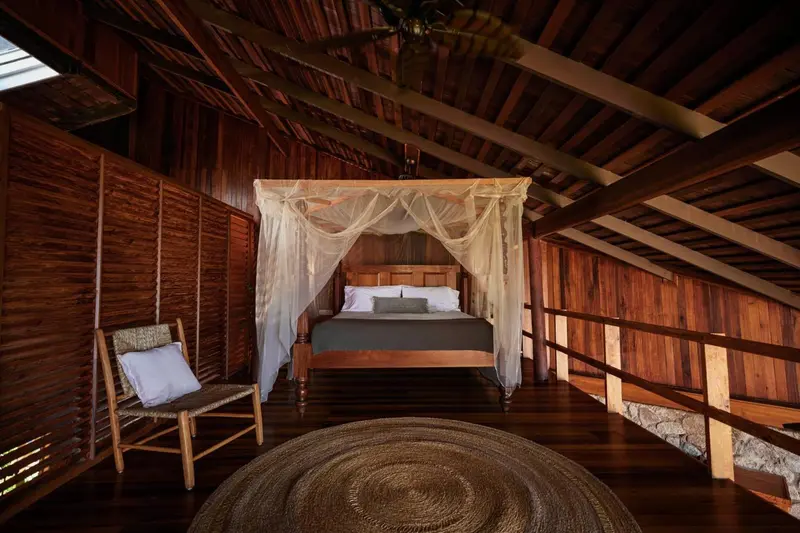 Une chambre avec un lit à baldaquin et une décoration en bois.