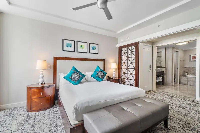 Une chambre lumineuse avec un grand lit et un accès à une salle de bain.