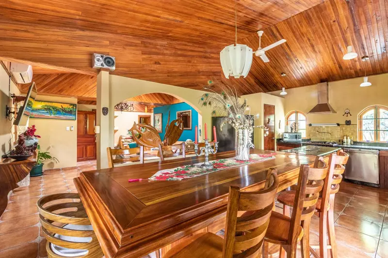 Grande salle à manger en bois avec une longue table et des chaises.
