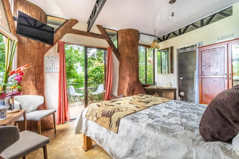 Une chambre à coucher lumineuse avec un lit recouvert d'une couverture décorative et un accès à une terrasse.