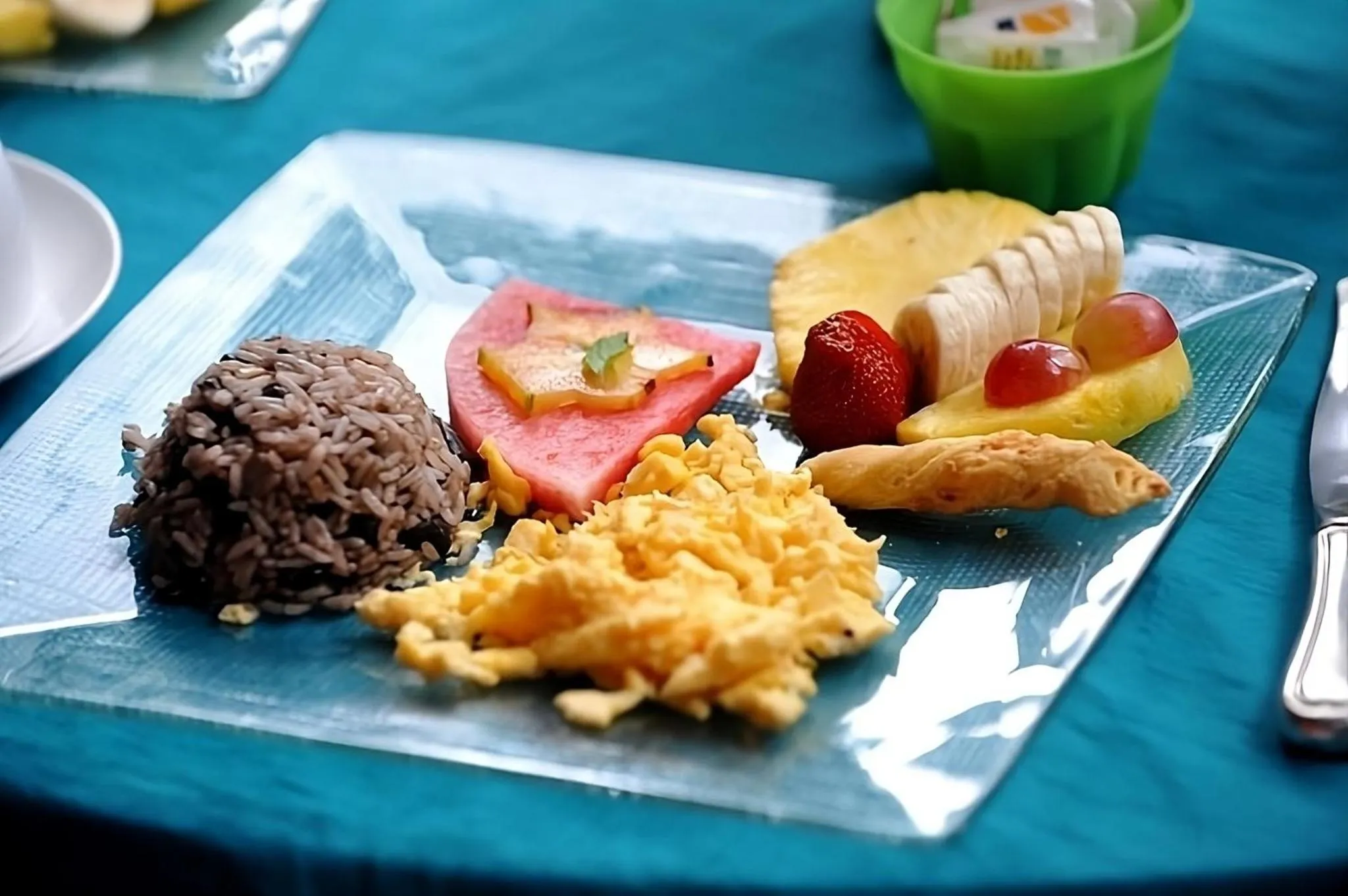 Assiette de fruits, riz, œufs brouillés et poisson.