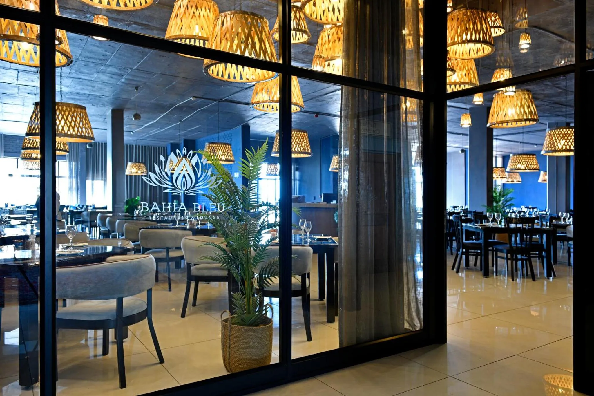 Une salle de restaurant lumineuse avec des tables et des chaises.