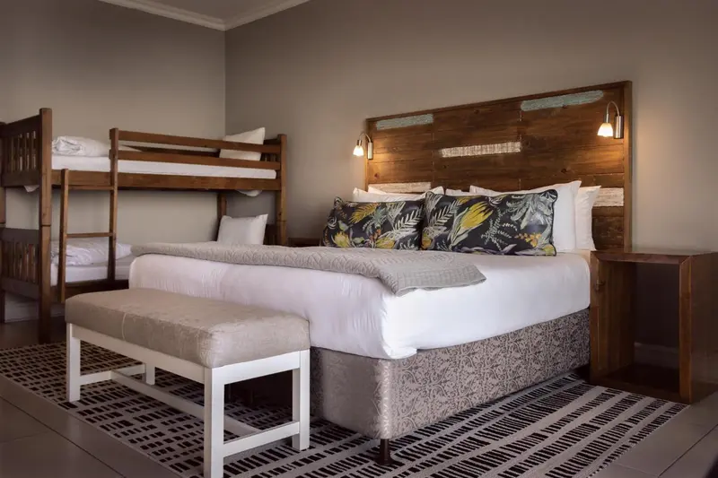 Une chambre avec un lit superposé et un grand lit double.