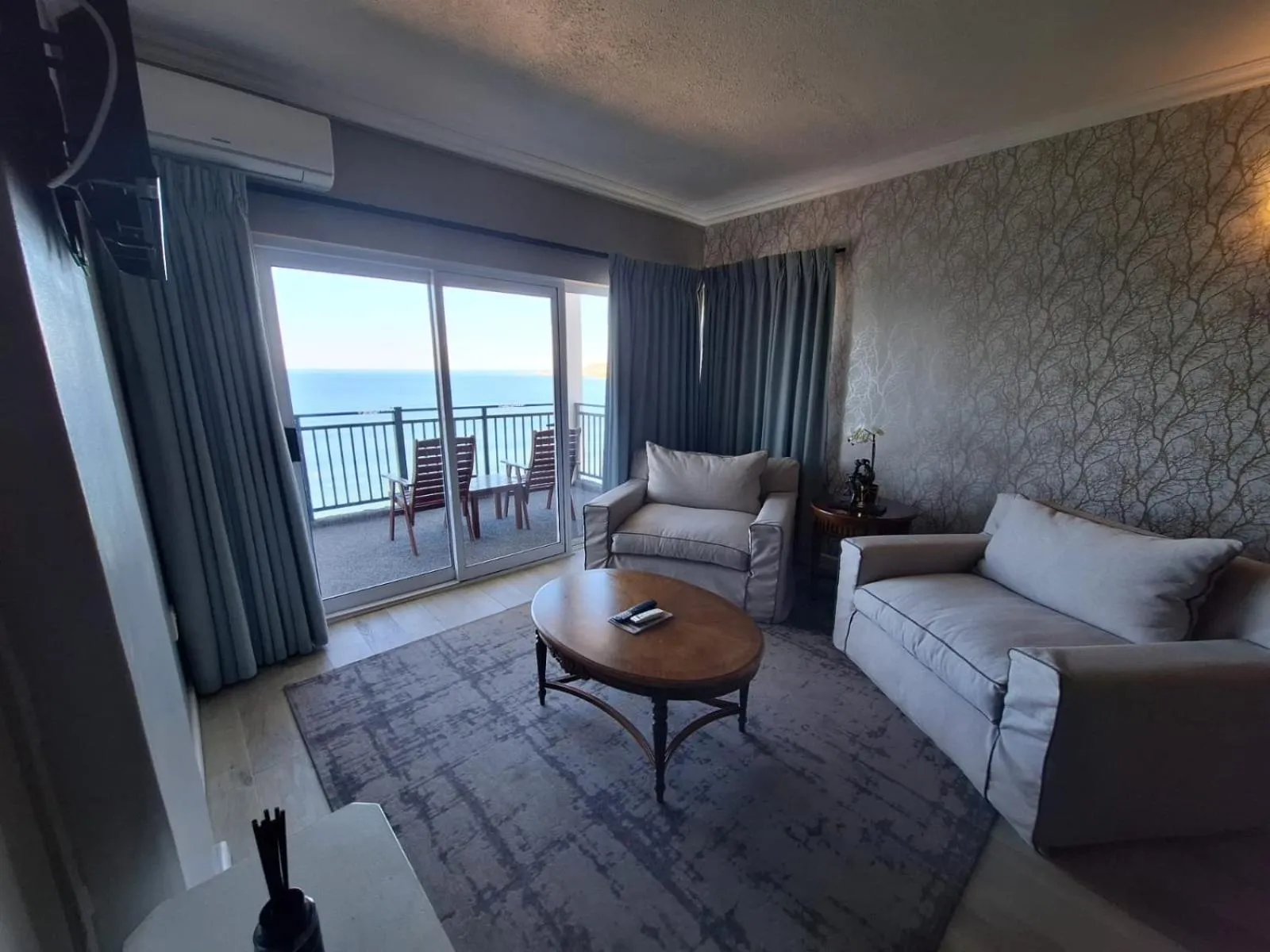 Un salon lumineux s'ouvre sur une terrasse avec vue sur la mer.