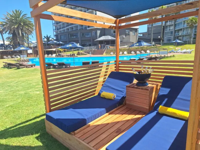 Espace de détente extérieur avec transats et pergola en bois.