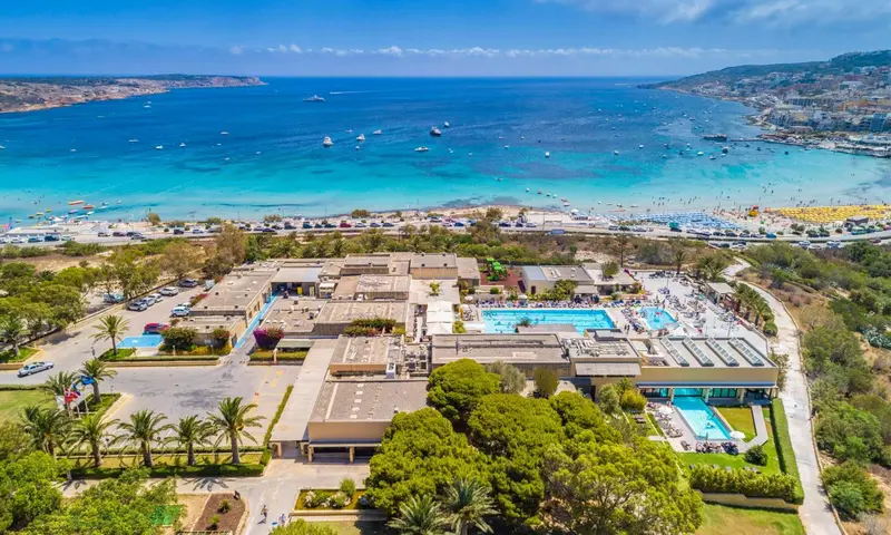 Vue aérienne d'un complexe hôtelier avec piscine et plage.