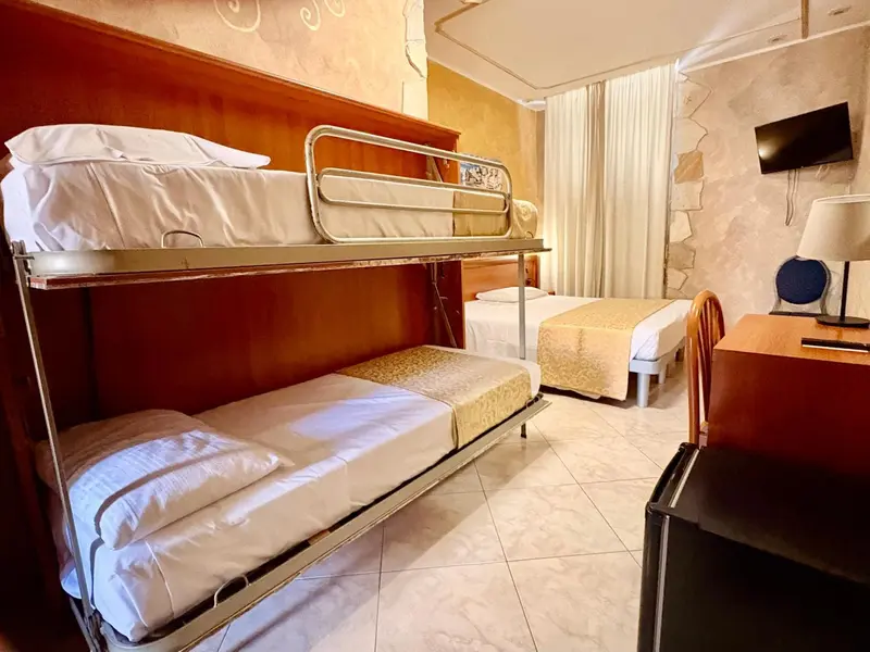 Une chambre avec un lit superposé et un lit simple.