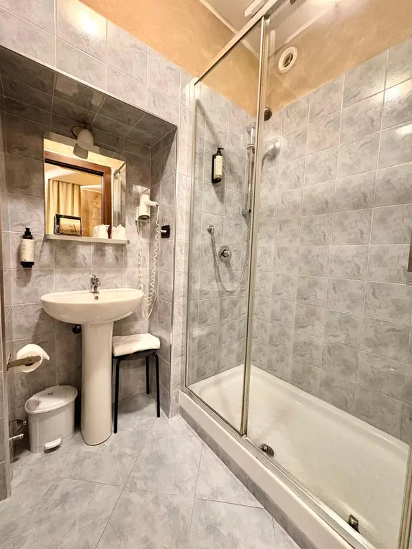 Une salle de bain avec douche à l'italienne et lavabo.