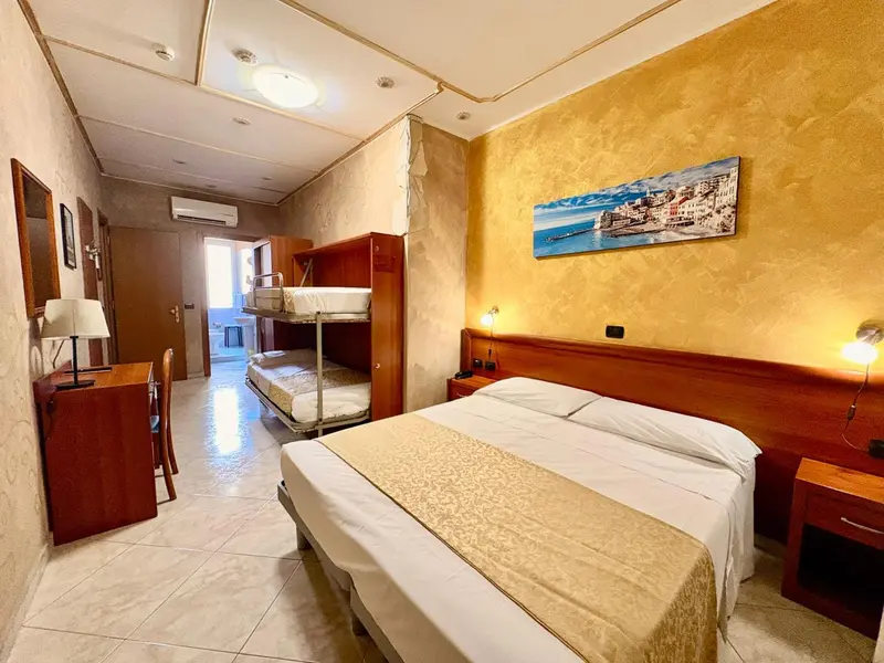 Une chambre avec un lit double et un lit superposé.