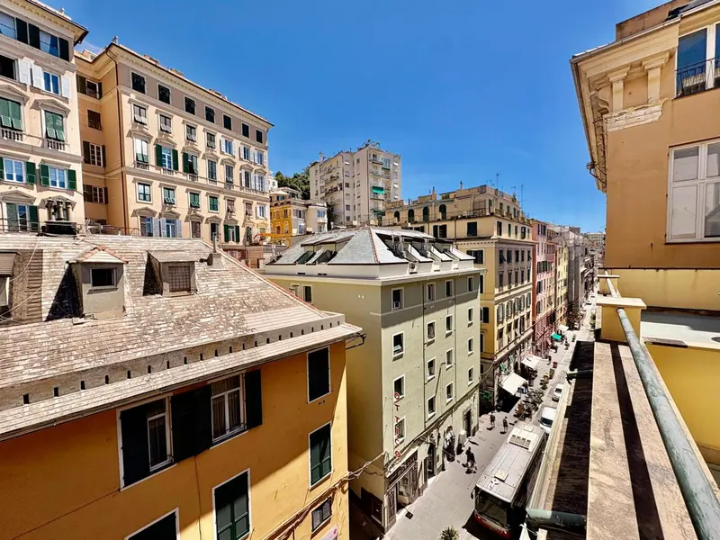 Vue d'une ruelle entre bâtiments colorés sous un ciel bleu.