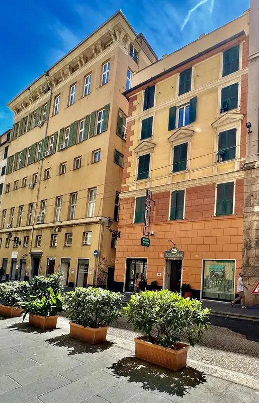 Façade d'un bâtiment jaune à plusieurs étages avec des fenêtres et des balcons.