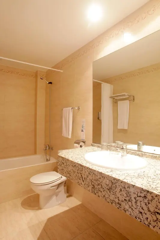 Une salle de bain claire avec baignoire, lavabo et toilettes.