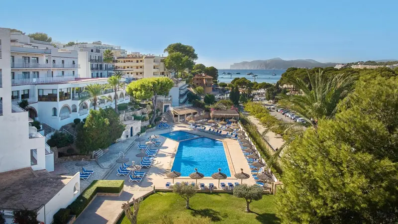 Vue aérienne d'un complexe hôtelier avec piscine et végétation luxuriante.