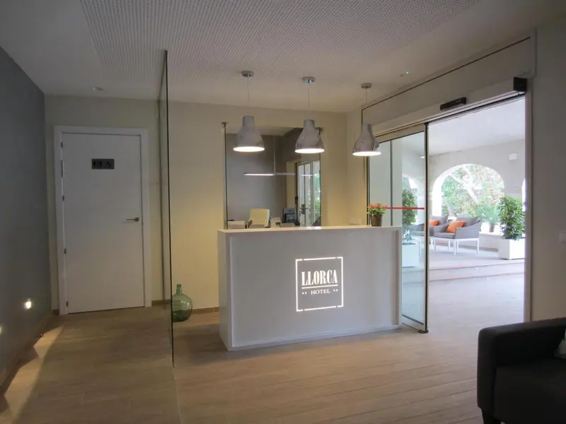 Hall d'accueil lumineux avec comptoir de réception et accès à une terrasse.