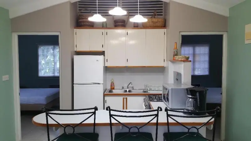 Une cuisine avec un coin repas et une vue sur une chambre.
