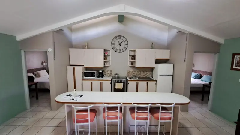 Une cuisine ouverte sur un espace repas avec des tabourets.