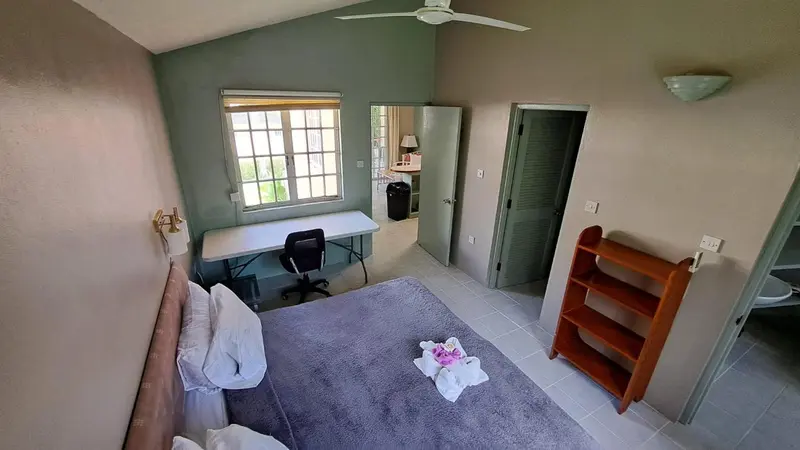 Une chambre lumineuse avec un lit, un bureau et un espace détente.