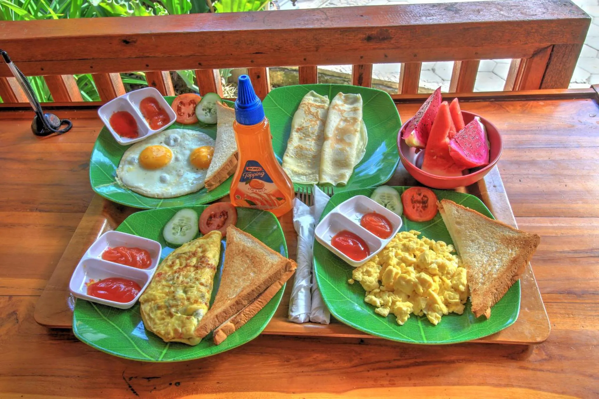 Assiette copieuse avec des œufs, des toasts, des crêpes et des fruits frais.