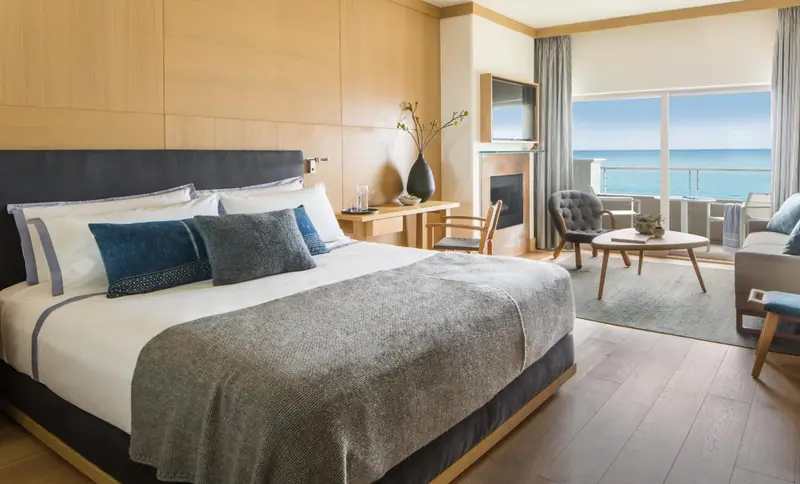 Une chambre lumineuse avec un grand lit et une vue sur la mer.