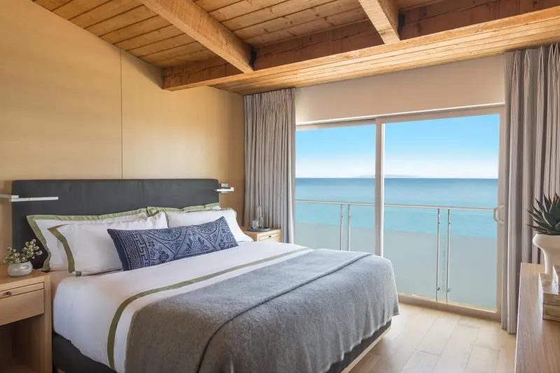 Une chambre lumineuse avec un grand lit donnant sur la mer.
