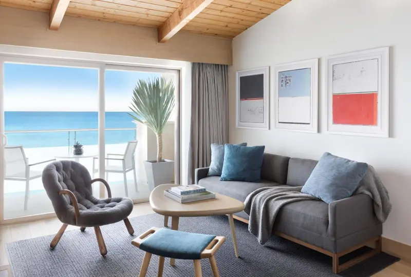 Un salon lumineux s'ouvre sur une terrasse avec vue sur la mer.