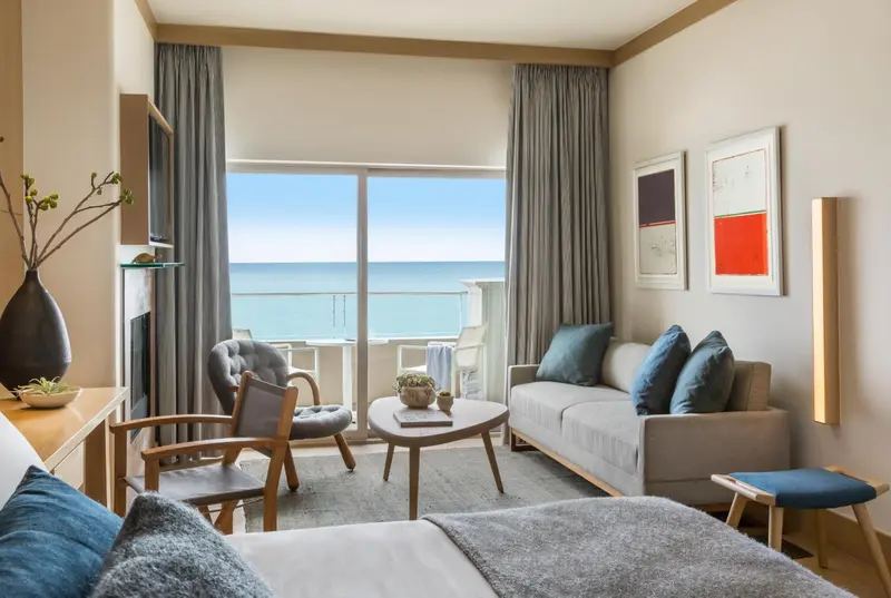 Espace de vie lumineux avec canapé et vue sur la mer.
