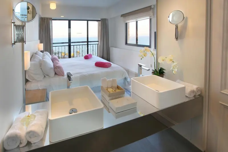 Une chambre lumineuse avec un grand lit et une salle de bain moderne.