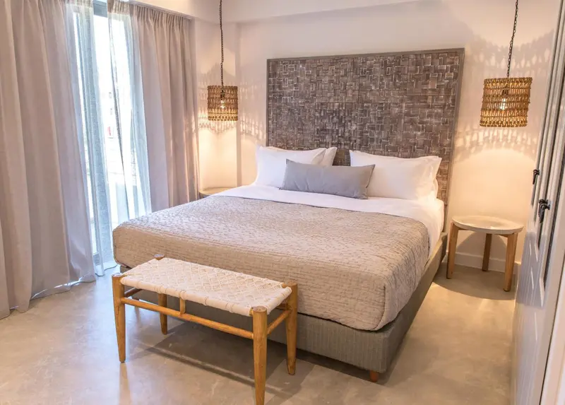 Une chambre lumineuse avec un grand lit et une décoration naturelle.