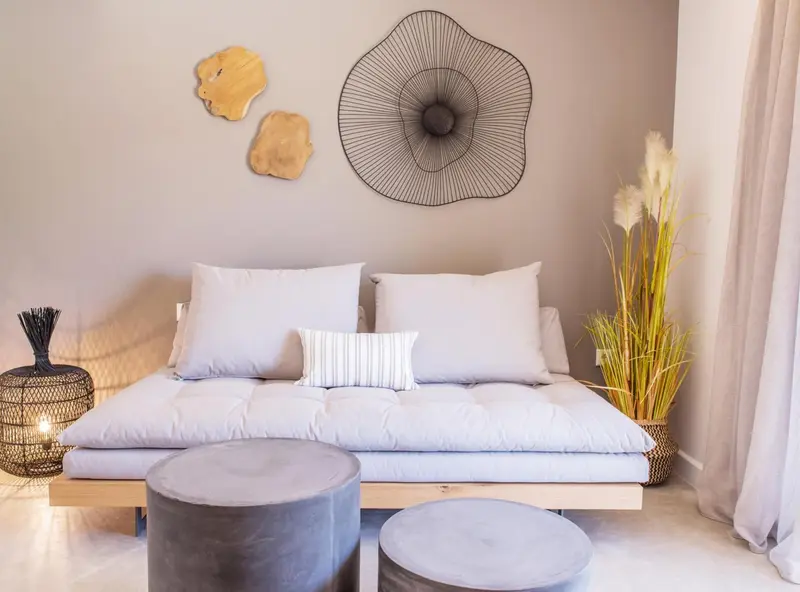 Canapé bleu clair et coussins dans une pièce décorée avec des éléments naturels.