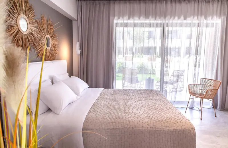 Une chambre lumineuse avec un grand lit et un accès à une terrasse.